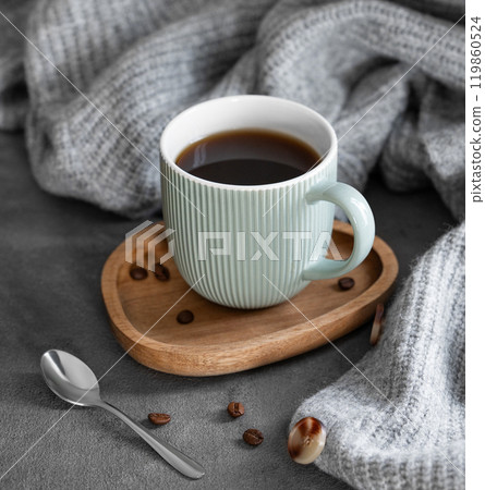 Espresso coffee in a mug on a wooden board on a dark background with coffee beans, spoon  119860524