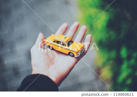 拿著一輛黃色小計程車的人的手 119860621