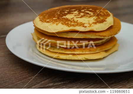 A wooden table with a plate of pancakes A wooden table with a plate of pancakes 119860651