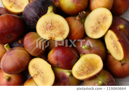 A cluster of ripe figs neatly arranged side by side on a surface 119860664