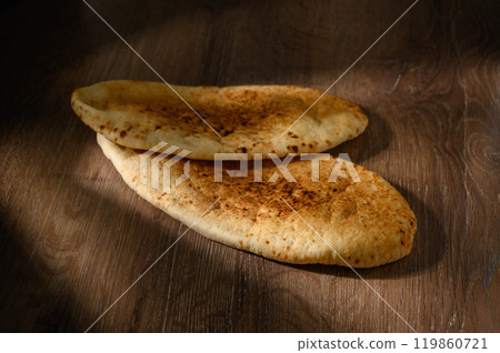 Freshly baked pita bread or flatbread on wooden background. Freshly baked pita bread or flatbread on wooden background. 119860721