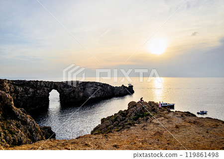 Spectacular sunset at Pont den Gil (Cala Corbetar) in Ciutadella, Menorca, Balearic Islands. Peculiar natural formation in the form of an arch 119861498