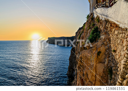 Beautiful sunset with orange sky on the beach of Menorca, Balearic Islands. Sunset, nature Beautiful sunset with orange sky on the beach of Menorca, Balearic Islands. Sunset, nature 119861531