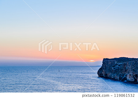 Beautiful sunset with orange sky on the beach of Menorca, Balearic Islands. Sunset, nature Beautiful sunset with orange sky on the beach of Menorca, Balearic Islands. Sunset, nature 119861532