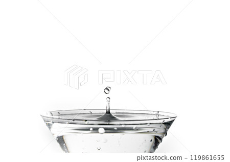 Close up of water drop falling into a glass on white background Close up of water drop falling into a glass on white background 119861655