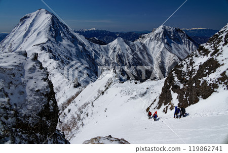 Climbers walking along the ridgeline of Mt. Yokodake in the Yatsugatake mountain range in midwinter, with a view of Mt. Akadake and Mt. Amidadake Climbers walking along the ridgeline of Mt. Yokodake in the Yatsugatake mountain range in midwinter, with a view of Mt. Akadake and Mt. Amidadake 119862741
