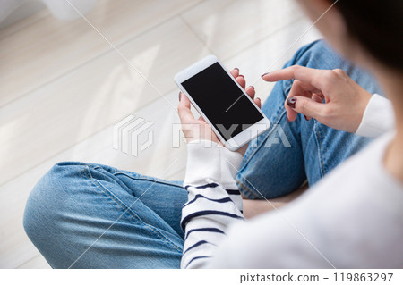 Woman operating a smartphone 119863297