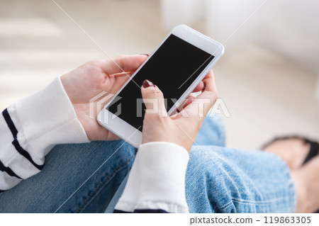 Woman operating a smartphone 119863305