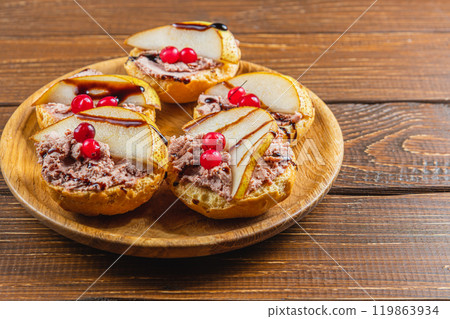 toast with chicken liver pate with pear, cranberry and sauce on a wooden table 119863934