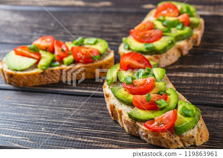 Avocado toast topped with tomato and green onion on a slice of carrot bread Avocado toast topped with tomato and green onion on a slice of carrot bread 119863961