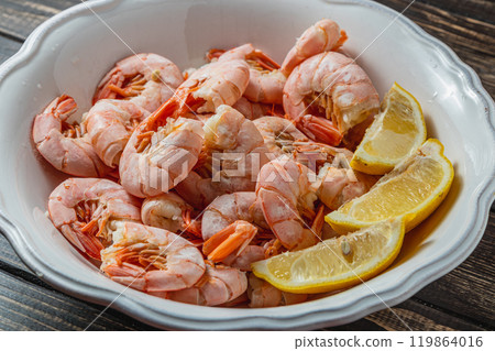 Tiger king prawns cooked and seasoned with lemon, on a wooden table 119864016
