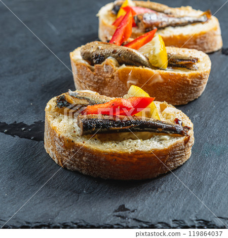 three fish sandwiches on a stone board on the table 119864037