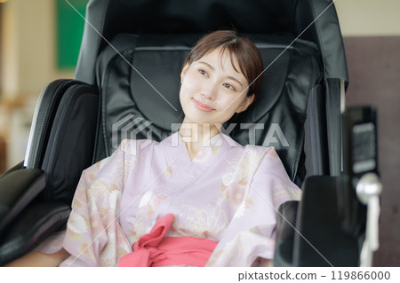 Young woman relaxing with a massage machine 119866000