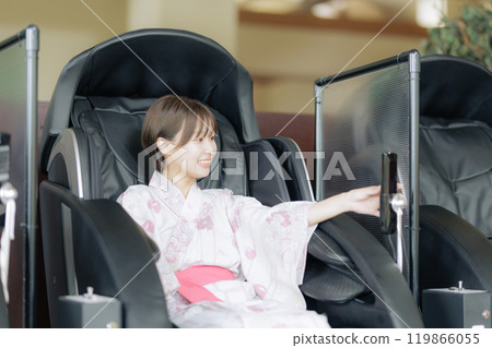 年輕女子用按摩機放鬆 年輕女子用按摩機放鬆 119866055