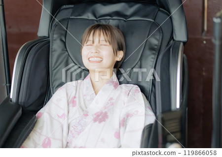 年輕女子用按摩機放鬆 年輕女子用按摩機放鬆 119866058