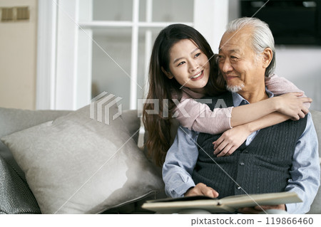 elderly asian father and adult daughter conversing at home 119866460