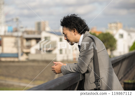 一位中年男子在夕陽下心情鬱悶,一事無成──這是冰河時期世代和中年危機的形象。 一位中年男子在夕陽下心情鬱悶,一事無成──這是冰河時期世代和中年危機的形象。 119867112