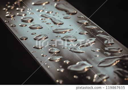 Detail of Water droplets caused by rain perched on the metallic surface. 119867635