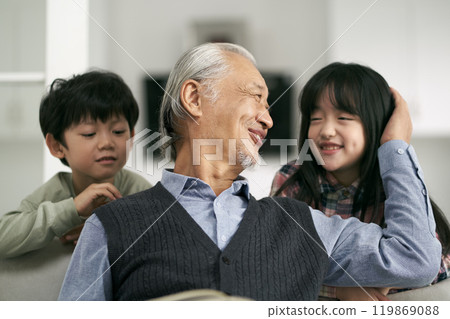asian grandpa and two grandchildren having a good time at home 119869088