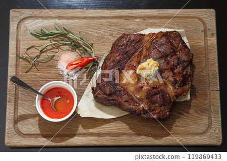 Medium rare steak placed on pita bread on a special wooden board. Beef steak on a wooden board. Medium rare steak placed on pita bread on a special wooden board. Beef steak on a wooden board. 119869433