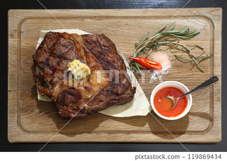 Medium rare steak placed on pita bread on a special wooden board. Beef steak on a wooden board. Medium rare steak placed on pita bread on a special wooden board. Beef steak on a wooden board. 119869434