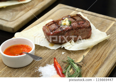 Medium rare steak placed on pita bread on a special wooden board. Beef steak on a wooden board. 119869447