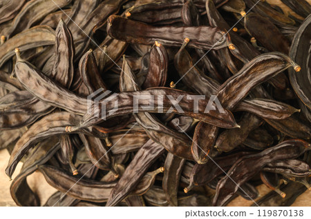 Carob pods and carob on rustic background Carob pods and carob on rustic background 119870138