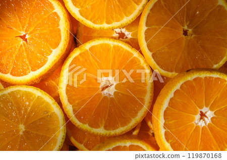 Colorful slices of fresh oranges as background with sun rays Colorful slices of fresh oranges as background with sun rays 119870168