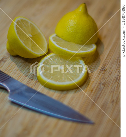Cutted lemons and silver knife over wooden cutting board . High quality photo Cutted lemons and silver knife over wooden cutting board . High quality photo 119870866