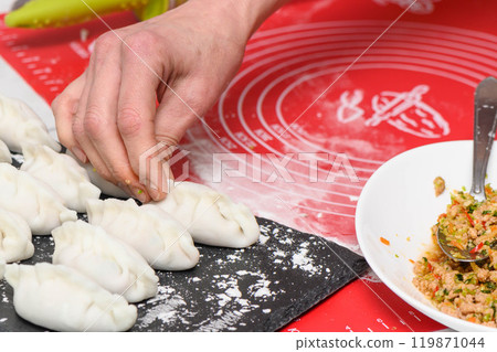 Hand molding. Dough with meat. Woman sculpt dumplings with her hands. 119871044