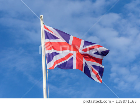 A vibrant Union Jack waving proudly under a clear blue sky, symbolizing British heritage and unity 119871163