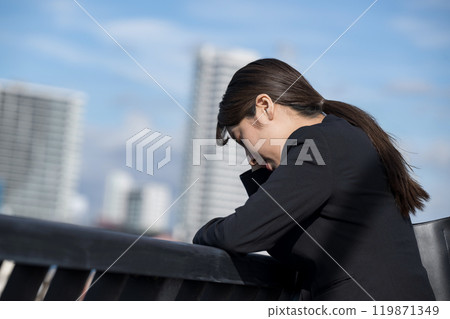 A young woman in a suit who is depressed about job hunting, changing jobs, and work A young woman in a suit who is depressed about job hunting, changing jobs, and work 119871349