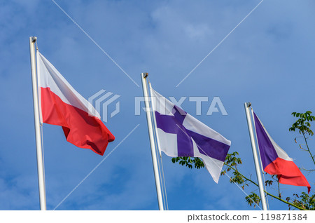 Three flags waving against a bright blue sky, symbolizing unity and heritage in a vibrant outdoor setting on a sunny day Three flags waving against a bright blue sky, symbolizing unity and heritage in a vibrant outdoor setting on a sunny day 119871384