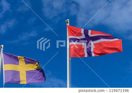 Colorful flags of Sweden and Norway waving against a bright blue sky in a lively summer breeze Colorful flags of Sweden and Norway waving against a bright blue sky in a lively summer breeze 119871396