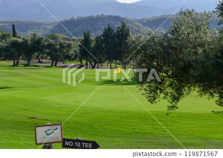 A tranquil afternoon on the lush golf course, featuring the tenth tee and a distant flag swaying gently in the breeze 119871567