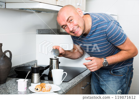 Man preparing coffee in moka pot in the kitchen Man preparing coffee in moka pot in the kitchen 119871612