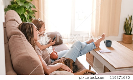 Happy family with cute dog watching TV in modern apartment 119871680