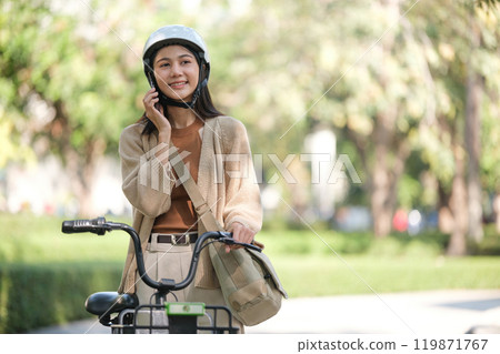 A woman is talking on her cell phone while riding a bicycle A woman is talking on her cell phone while riding a bicycle 119871767