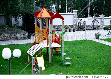 Colorful playground with slide and climbing structure in park. Colorful playground with slide and climbing structure in park. 119874377