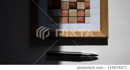 Pen on beautiful white fon on warm light. Wooden picture frame. Pen on beautiful white fon on warm light. Wooden picture frame. 119874871