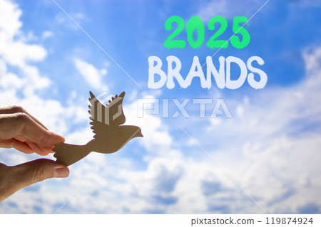 Planning 2025 brands new year symbol. Concept words 2025 Brands on beautiful blue sky. Beautiful blue sky clouds background. Hand with wooden bird. Business 2025 brands new year concept. Copy space. Planning 2025 brands new year symbol. Concept words 2025 Brands on beautiful blue sky. Beautiful blue sky clouds background. Hand with wooden bird. Business 2025 brands new year concept. Copy space. 119874924