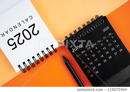 June 2025 desk calendar black and white color with pencil on orange background. 119875944