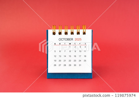 October 2025 white desk calendar on red background. 119875974