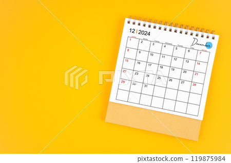 December 2024 desk calendar on yellow color background. December 2024 desk calendar on yellow color background. 119875984