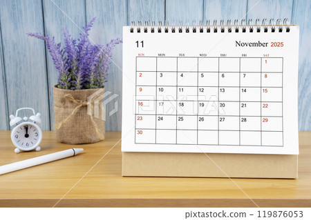 November Monthly desk calendar for 2025 year and alarm clock. 119876053