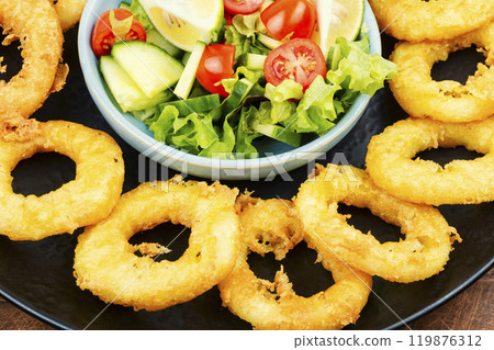 Delicious golden calamari served with fresh salad. Delicious golden calamari served with fresh salad. 119876312
