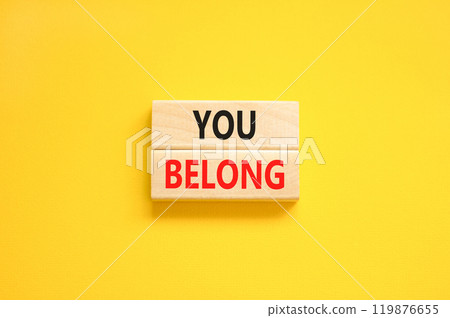 Belonging and you belong symbol. Concept words You belong on beautiful wooden blocks. Beautiful yellow background. Business belonging and you belong concept. Copy space. 119876655
