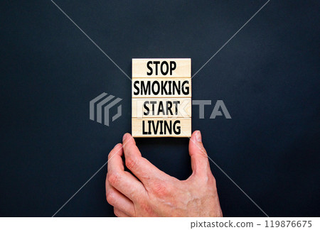 Stop smoking start living symbol. Concept words Stop smoking start living on cubes. Beautiful black background. Doctor hand. Medical healthy lifestyle stop smoking start living concept. Copy space. 119876675