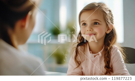 A little girl at a pediatrician's appointment sits in a cabinet and looks smiling at pediatrician. A well-behaved preschool child A kid with a teacher This is AI-generated item 119877223