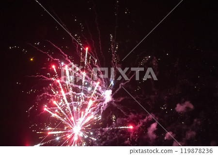 On a black background, red rays and sparks of a scattering fireworks with smoke. On a black background, red rays and sparks of a scattering fireworks with smoke. 119878236